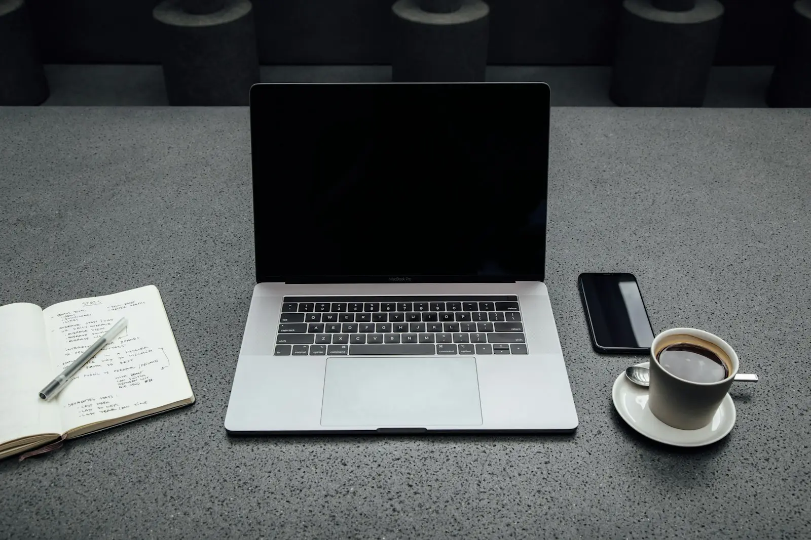 Laptop, coffee, phone and notebook ready for a planning session